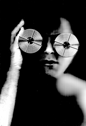 A photo of a blurred face with metal glasses in black and white